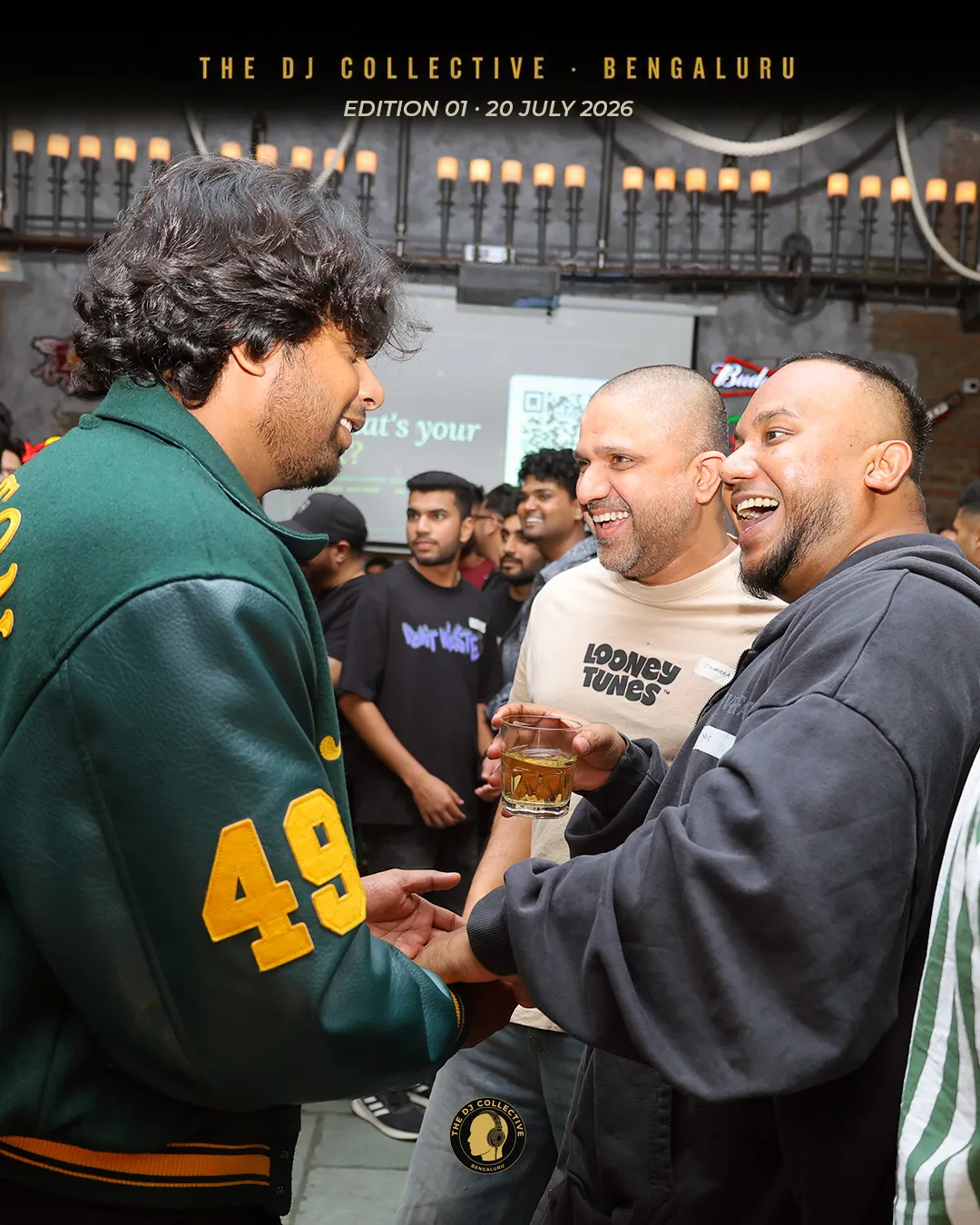 Three DJs laughing together, drinks in hand
