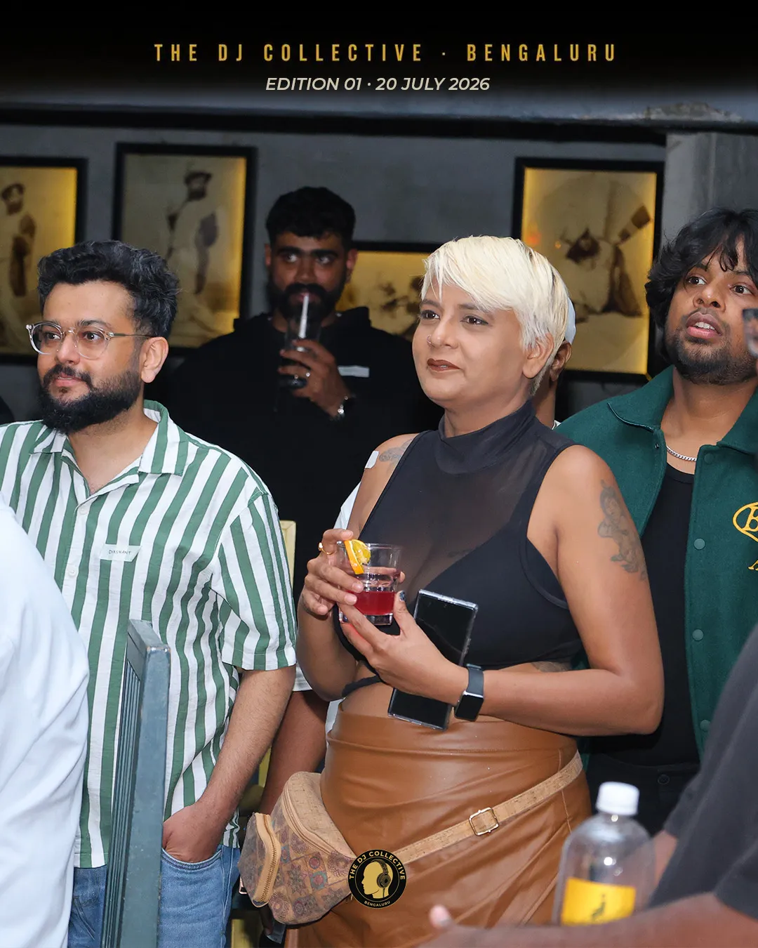 Three people standing and talking, drinks in hand