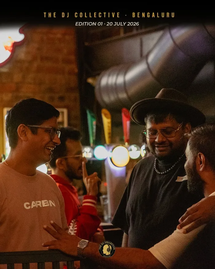 A group talking near the bar, one in a wide-brim hat