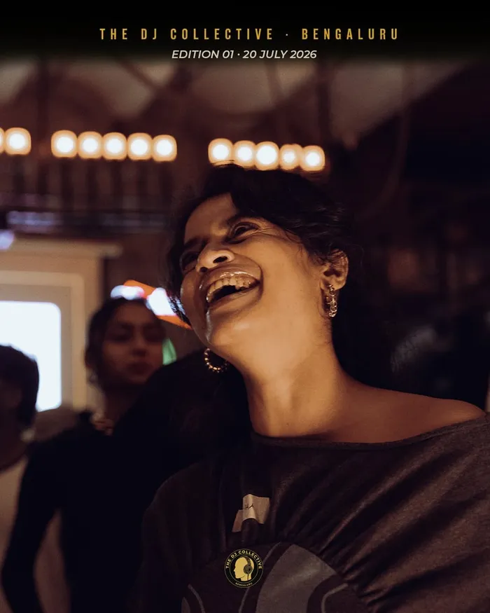 A DJ thrown back in laughter under the lights