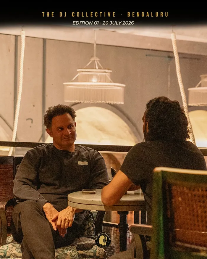 A DJ seated at a table, relaxed, looking to camera